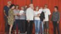 Entouré par des personnes malades, des bénévoles et d’autres aidants, Robert (au centre) fait admirer la justesse de sa voix.